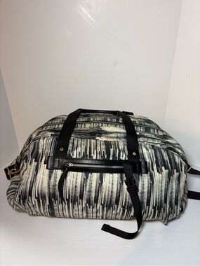 Lululemon All You Need duffel bag features a black and cream with gold hardware